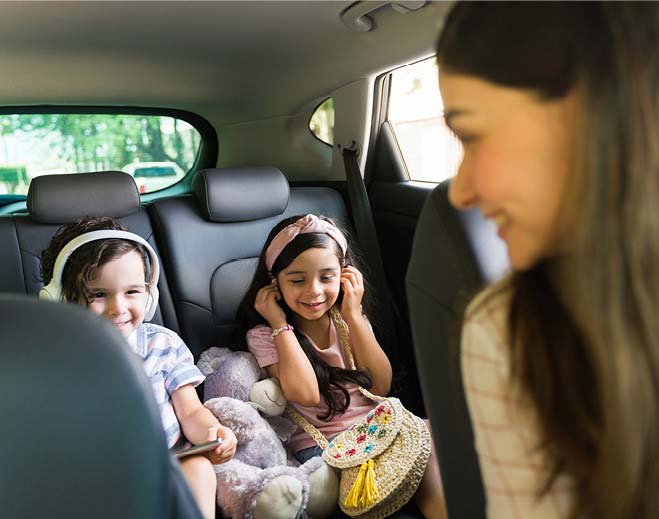 mother driving her two daughters to school